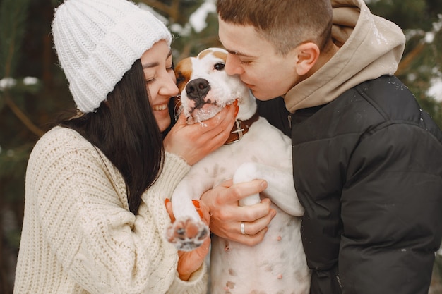 Lifestyle shot of couple in snowy forest with dog