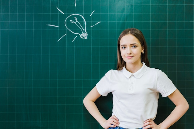 Ligh bulb on the blackboard and student posing