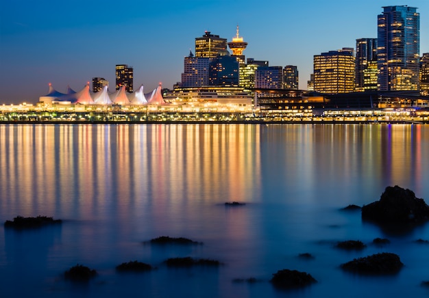 Free photo lighted high-rise buildings near body of water