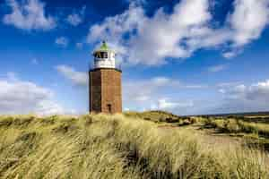 Free photo lighthouse quermarkenfeuer in kampen, sylt, germany under the cloudy sky