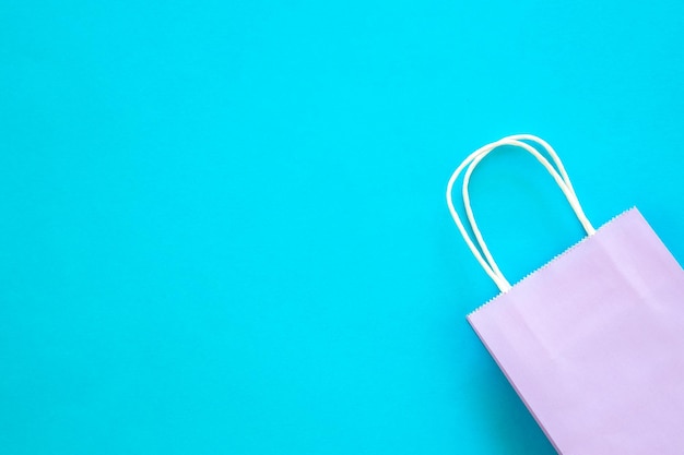 Free photo lilac paper bag on a blue background top view