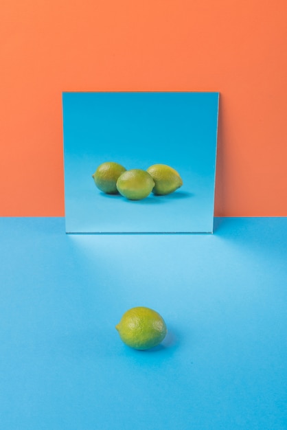 Free photo lime on blue table isolated on orange