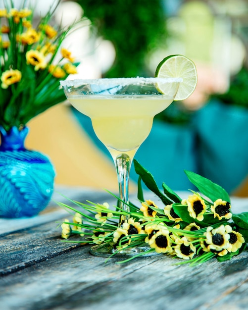 Lime cocktail garnished with lime slice in glass decorated with sugar sprinkles