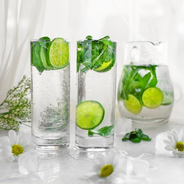 Lime mojito glasses with mint leaves in white