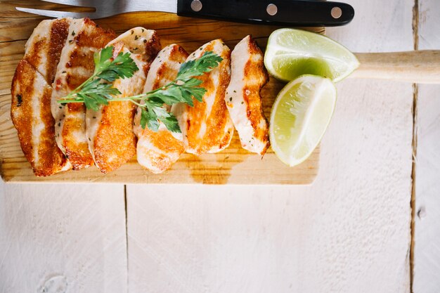 Lime near roasted meat on cutting board