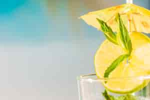 Free photo lime slice with peppermint leaf under umbrella