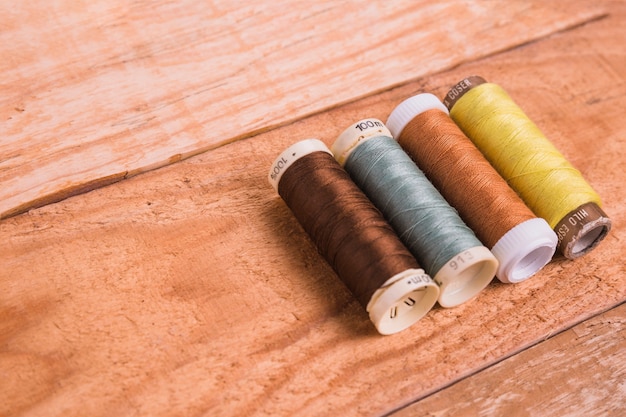 Free photo line of reel of yarn on wooden background