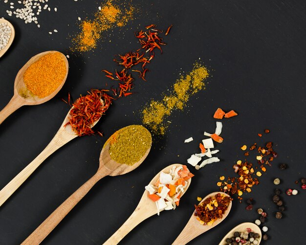 Line of wooden spoons full of spices