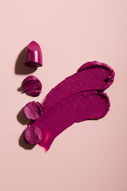 Lipstick shade on pink background above view