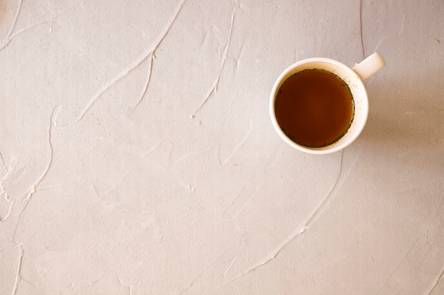 Free photo liquid in ceramic white cup on concrete background