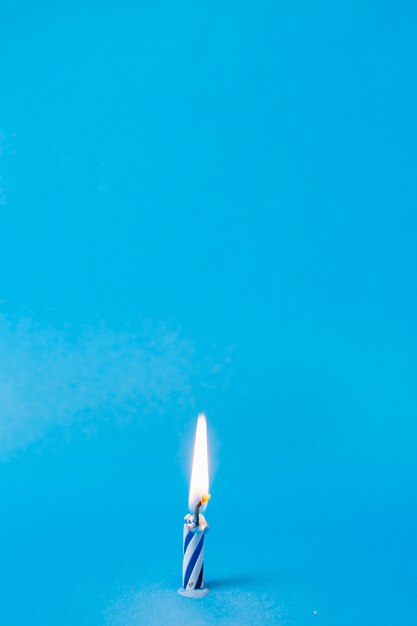 Lit blue birthday candle with copy space