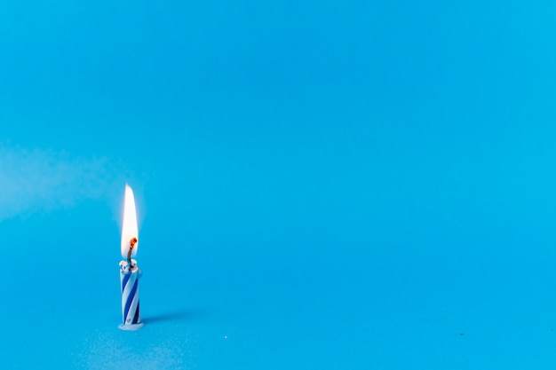 Free photo lit candle on blue background