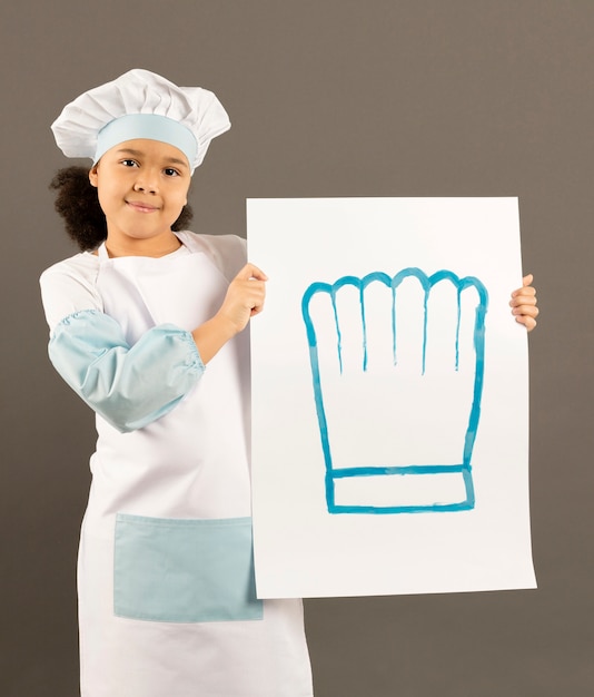 Free photo little afroamerican chef holding banner