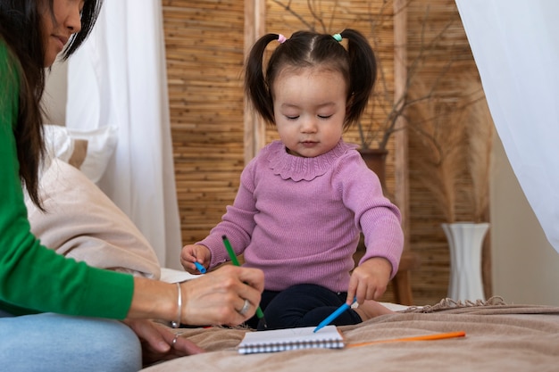 Little asian girl spending time at home with her mother