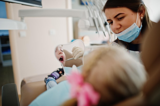 Little baby girl at dentist chair Children dental