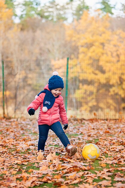 little baby girl playing in autumn leaves