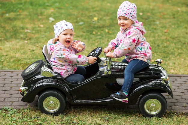 Free photo the little baby girls playing with a car