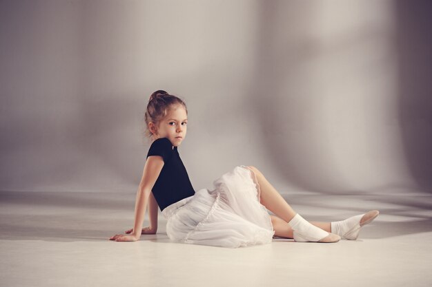 The little balerina dancer on gray wall