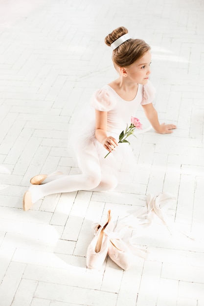 Free photo the little balerina in white tutu in class at the ballet school