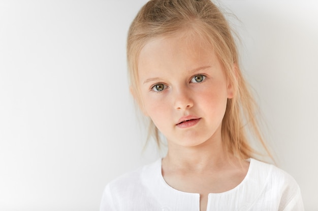 Little blonde girl wearing white blouse