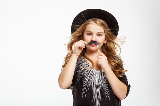 Little blonde girl with blue eyes. Posing with moustache mask.