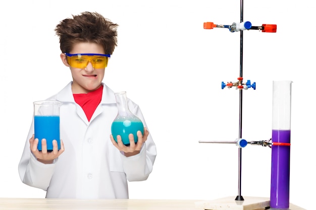 Free photo little boy as chemist doing experiment with chemical fluid in the laboratory