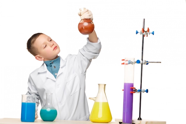 Free photo little boy as chemist doing experiment with chemical fluid in the laboratory