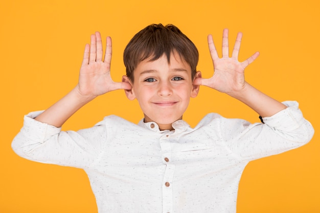 Little boy being silly with orange background