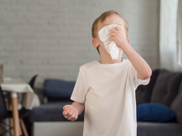 Little boy blowing nose