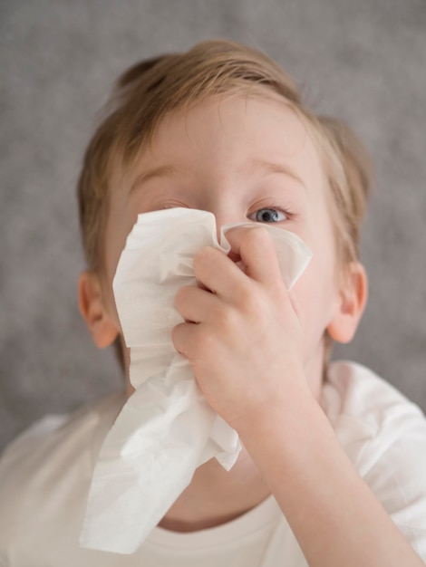 Free photo little boy blowing nose