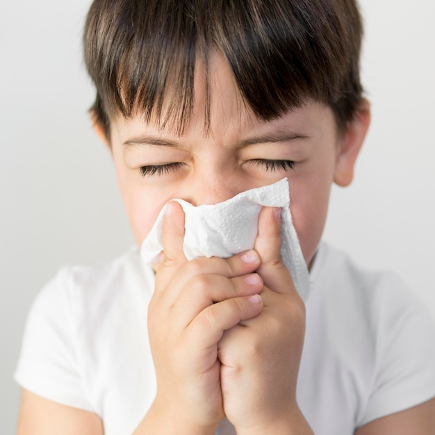 Little boy blowing nose