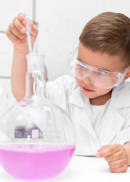 Little boy doing an experiment at school