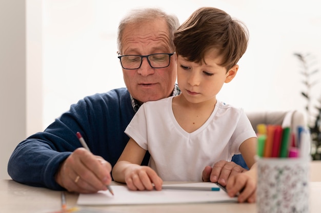 Little boy doing homework with his grandmother