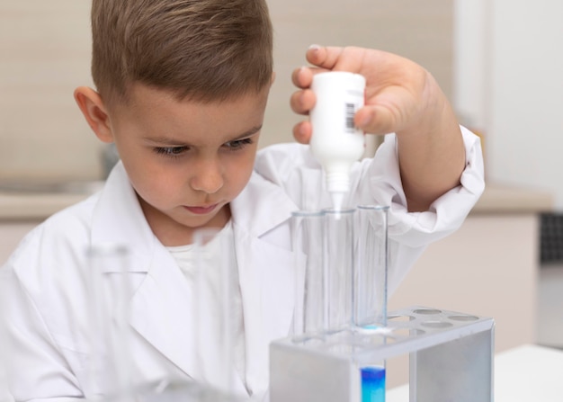 Little boy doing a science experiment at school