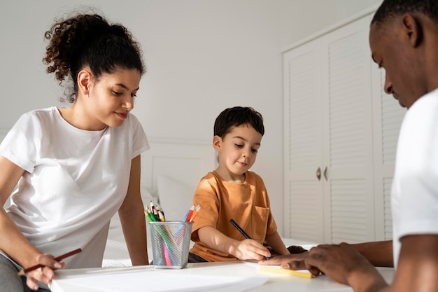 Little boy drawing his father hand on paper