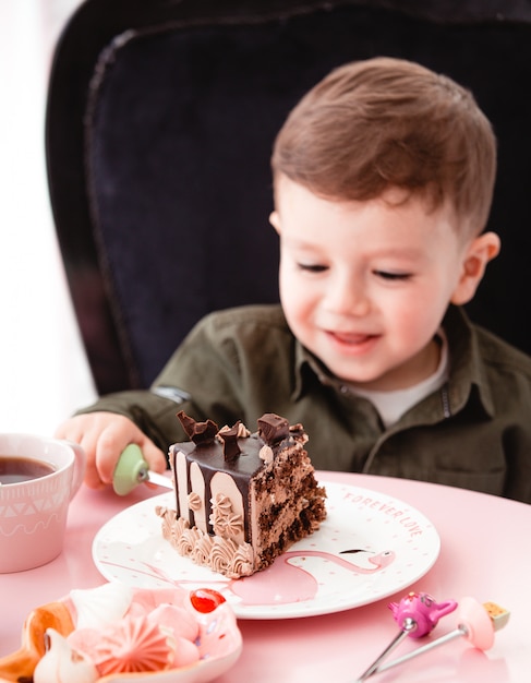 Free photo little boy eats chocolate cake