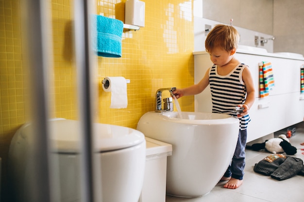 Free Photo little boy fixing in bathroom