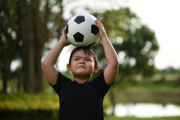 Free Photo little boy hand holding soccer football