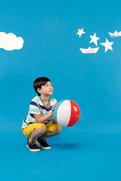 Free Photo little boy having fun in a summer setting studio