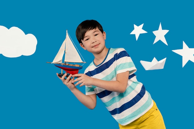 Little boy having fun in a summer setting studio