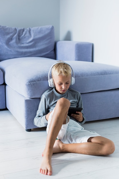 Little boy having fun with tablet and earphones