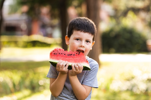 Little boy having watermelon outdoor