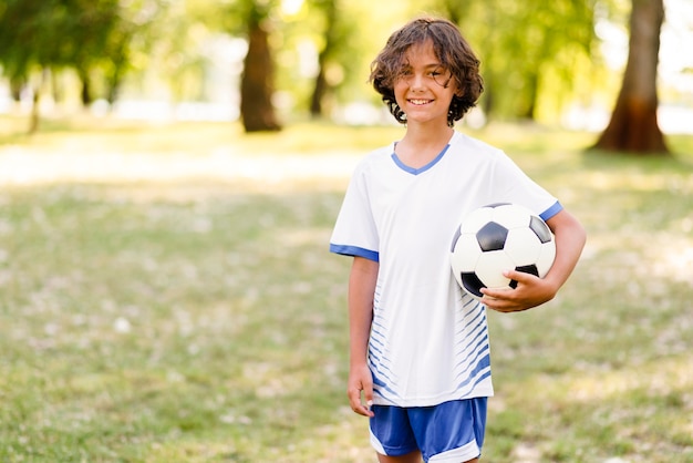 Little boy holding a football with copy space