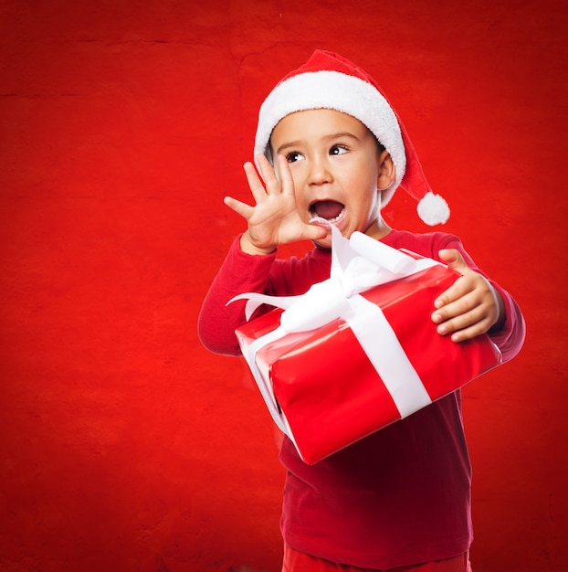 Little boy holding a gift and screaming