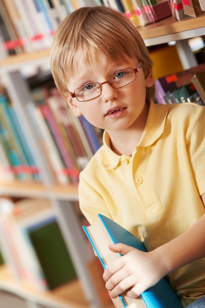 Free photo little boy holding a thick book