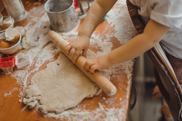 little boy in the kitchen helps mom to cook. the child is involved in cooking.