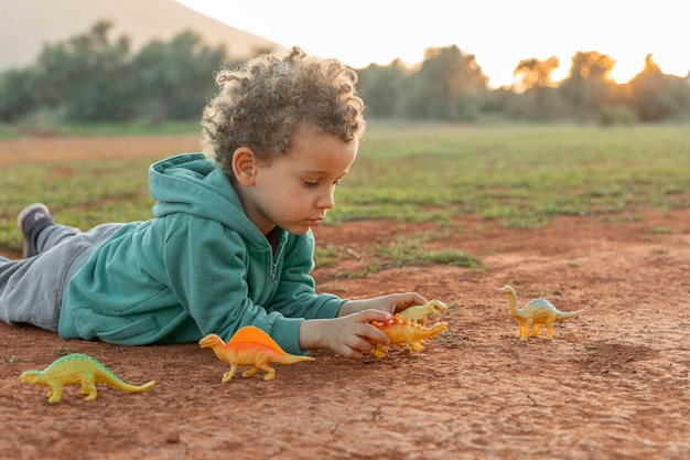 Free photo little boy outdoors playing with toys