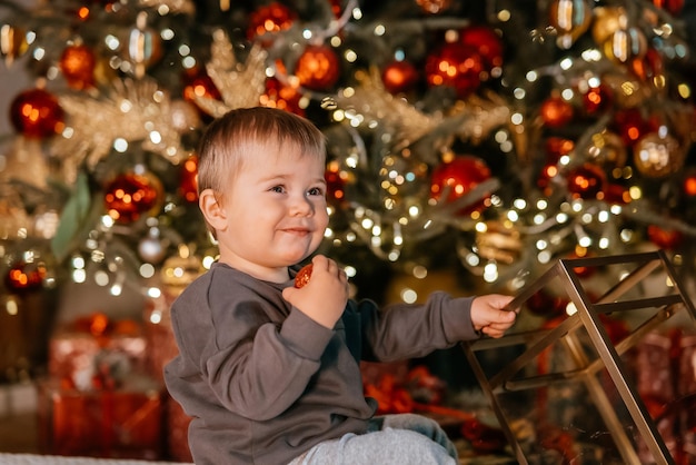 Little boy playing by the christmas tree