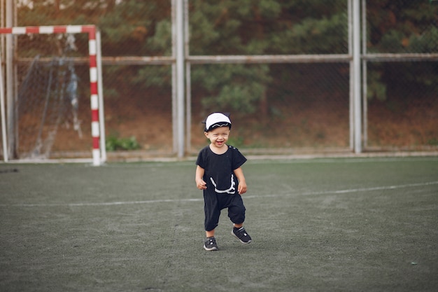 Free Photo little boy playing football in a sports ground