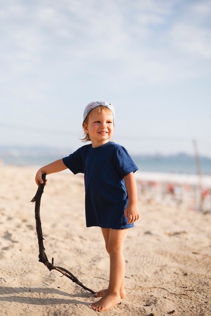 Little boy playing with stick at beach